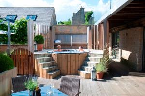 a backyard with a hot tub and a patio with two kids in it at Feversham Arms Hotel & Verbena Spa in Helmsley
