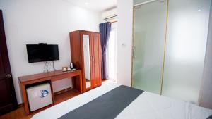 a bedroom with a bed and a tv and a window at Saigon Hub Hostel in Ho Chi Minh City