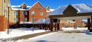 ein Hotel mit Schnee auf dem Boden vor einem Gebäude in der Unterkunft Country Inn & Suites by Radisson, Duluth North, MN in Duluth