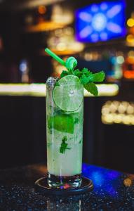 a drink with a lime and a mint leaf on a table at Saigon Hub Hostel in Ho Chi Minh City