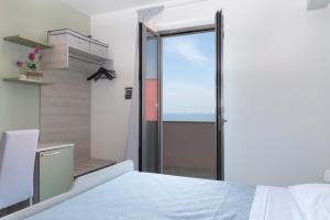 Torre ForteにあるHZ bed & breakfast and apartmentsのベッドルーム1室(バルコニーへ続くガラスドア付)
