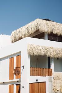 - un bâtiment blanc au toit de chaume dans l'établissement Casa Luni, à Puerto Escondido