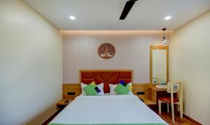 1 dormitorio con cama, mesa y espejo en Treebo Trend Aasma Downtown, en Bhubaneshwar