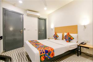 a hotel room with a large bed and a desk at FabHotel Chawla House in New Delhi