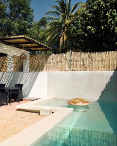 a pizza sitting on a table next to a swimming pool at Casa Luni in Puerto Escondido