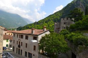 a view of an old building and a mountain at Residence Porta Della Muda in Vittorio Veneto