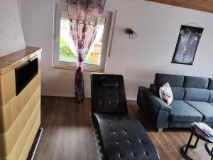 ein Wohnzimmer mit einer Couch und einem Sessel in der Unterkunft Ferienhaus Hermann in Schönwald