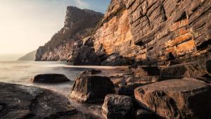 una playa rocosa con rocas en el agua en 23Apartments en La Spezia