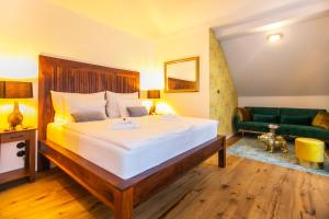 sypialnia z dużym łóżkiem i zieloną kanapą w obiekcie Pension Adalbert w Czeskim Krumlovie