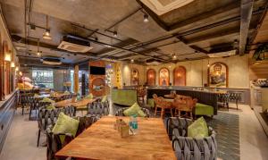 un ristorante con tavoli e sedie in legno e un bar di Treebo Trend Aasma Downtown a Bhubaneshwar