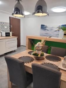 eine Küche mit einem Tisch mit Stühlen und einer Schale mit Blumen darauf in der Unterkunft Pokoje na Warszawskiej in Gorzów Wielkopolski