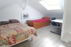 1 dormitorio con cama, escritorio y mesa en Comme à la maison en Cenon