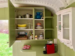 a green cabinet with some dishes in it at 't Keetje in Groesbeek