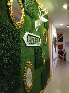 a green wall with mirrors and a hotel sign on it at Fantasy Hotel in Malacca