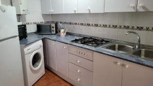a kitchen with a sink and a stove top oven at Mi Casa En Benamahoma in Benamahoma