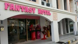 una tienda con un cartel rosa en la parte delantera de un edificio en Fantasy Hotel, en Melaka