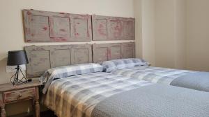2 camas individuales en una habitación con mesa y armarios en Mi Casa En Benamahoma, en Benamahoma