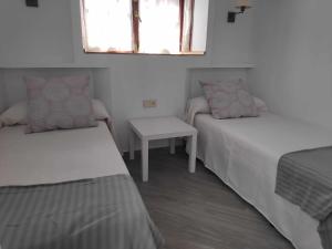 a small room with two beds and a table at Sonsoles Apartamentos Bahía Sur in San Fernando +42 photos