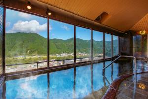 a large indoor swimming pool with a view of the mountains at Ooedo Onsen Monogatari Masuya in Osaki