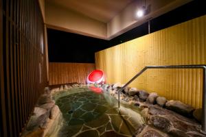 a swimming pool in a room with a rock wall at Ooedo Onsen Monogatari Masuya in Osaki