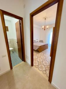 a doorway to a bedroom with a bed and a mirror at CASA ROSARIA in Cefalù