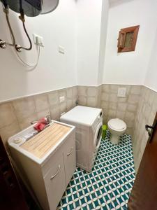 a small bathroom with a toilet and a sink at CASA ROSARIA in Cefalù