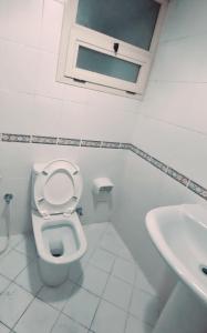 Baño blanco con aseo y lavamanos en MBZ - Nice Bed Space "MEN", en Abu Dabi