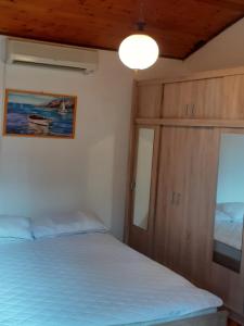 a bedroom with a bed and a cabinet and a light at Apartments Rudi in Klenovica