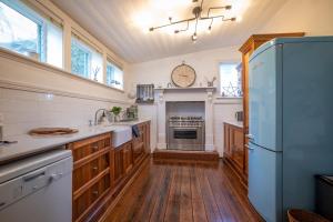 eine Küche mit Holzböden und einem Kühlschrank in der Unterkunft Cosy coastal cottage- Allwood Harbour in Kiama