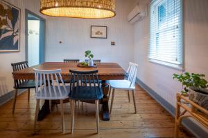 ein Esszimmer mit einem Holztisch und Stühlen in der Unterkunft Cosy coastal cottage- Allwood Harbour in Kiama + 17 Fotos