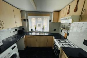 a kitchen with a sink and a stove top oven at Cosy Flat Close To East Finchley Station in London