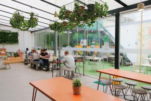 a group of people sitting at tables in a cafeteria at WOT Patio Social in Lisbon