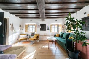 a living room with a green couch and a table at Hiša Borov Gaj in Mojstrana