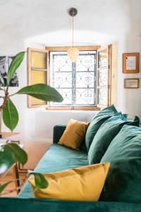 un sofá verde en una sala de estar con ventana en Hiša Borov Gaj, en Mojstrana