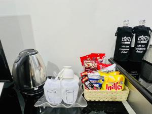 einen Tisch mit Snacks und eine Kaffeemaschine darauf in der Unterkunft Bed by Tha-Pra SHA Plus in Bangkok