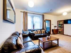 a living room with a leather couch and a table at Pass the Keys 3 Bedroom Cottage in Cupar in Cupar