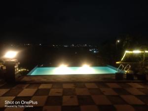 a swimming pool at night with lights at Eleson Cliffside Retreat in Panchgani