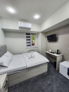 a bedroom with a bed and a desk with a television at Paradise inn in Tashkent +114 photos