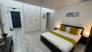 a bedroom with a large bed with yellow pillows at LUXURY STUDIO in Onești
