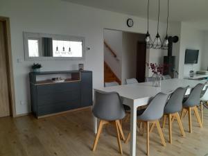a kitchen and dining room with a white table and chairs at Lipnohaus in Horní Planá