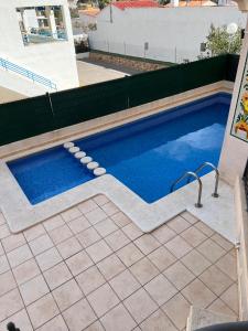 a swimming pool in the middle of a yard at Residencial Los Almendros Playa Romana in Alcossebre