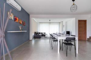 comedor y sala de estar con mesa blanca y sillas en Villa Sikania Seaview Scopello, en Castellammare del Golfo