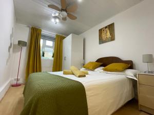 a bedroom with a large white bed with yellow pillows at Cosy Flat Close To East Finchley Station in London