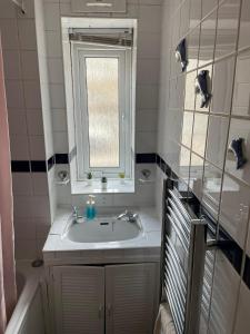 a bathroom with a sink and a window at Cosy Flat Close To East Finchley Station in London