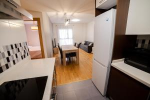 eine Küche und ein Wohnzimmer mit einem Tisch und einem Kühlschrank in der Unterkunft Castellon Ribalta Apartments - Parking disponible in Castellón de la Plana