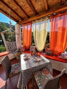 a porch with a table and chairs and a hammock at Lauricella Bed and Breakfast in Lipari