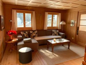 ein Wohnzimmer mit einem Sofa und einem Tisch in der Unterkunft Charmantes Alpen-Appartement in Conters, Davos-Parsenn in Conters