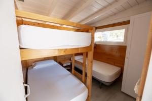 Camping Joncar Mar في روساس: غرفة صغيرة مع سريرين بطابقين ومرحاض