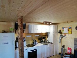 uma cozinha com armários brancos e um frigorífico em Lili’s Holiday House em Otepää