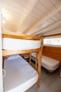 ロザスにあるCamping Joncar Marの二段ベッド2台とベンチが備わる小さな客室です。